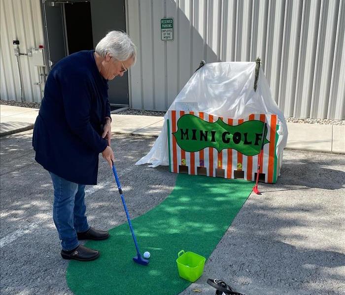 Insurance agent playing a golfing game at one of the festival booths.
