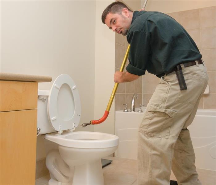 A plumber working in a bathroom